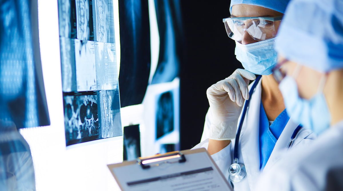 Two female women medical doctors looking at x-rays in a hospital.